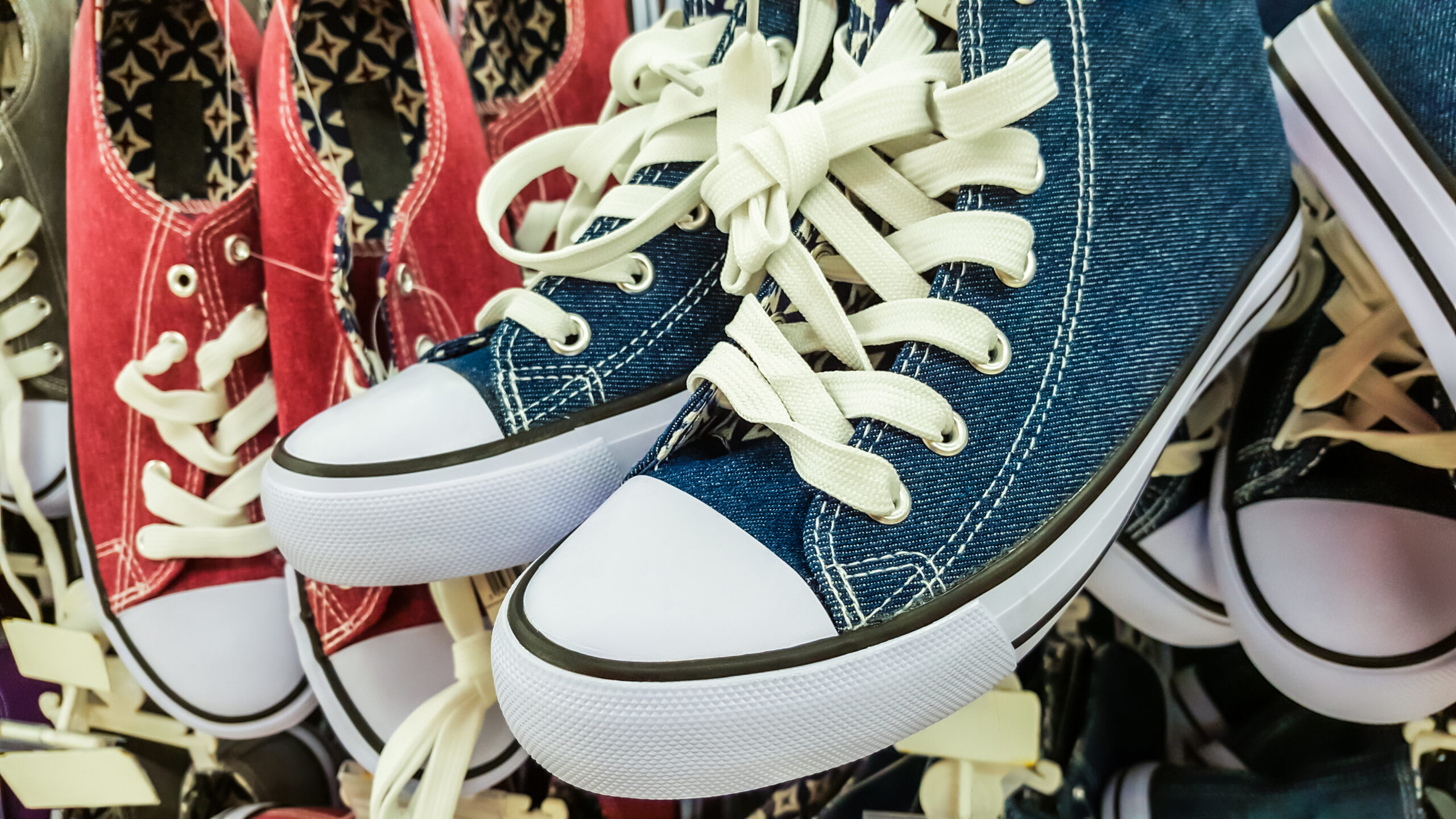 Many pair of sneakers in a store.